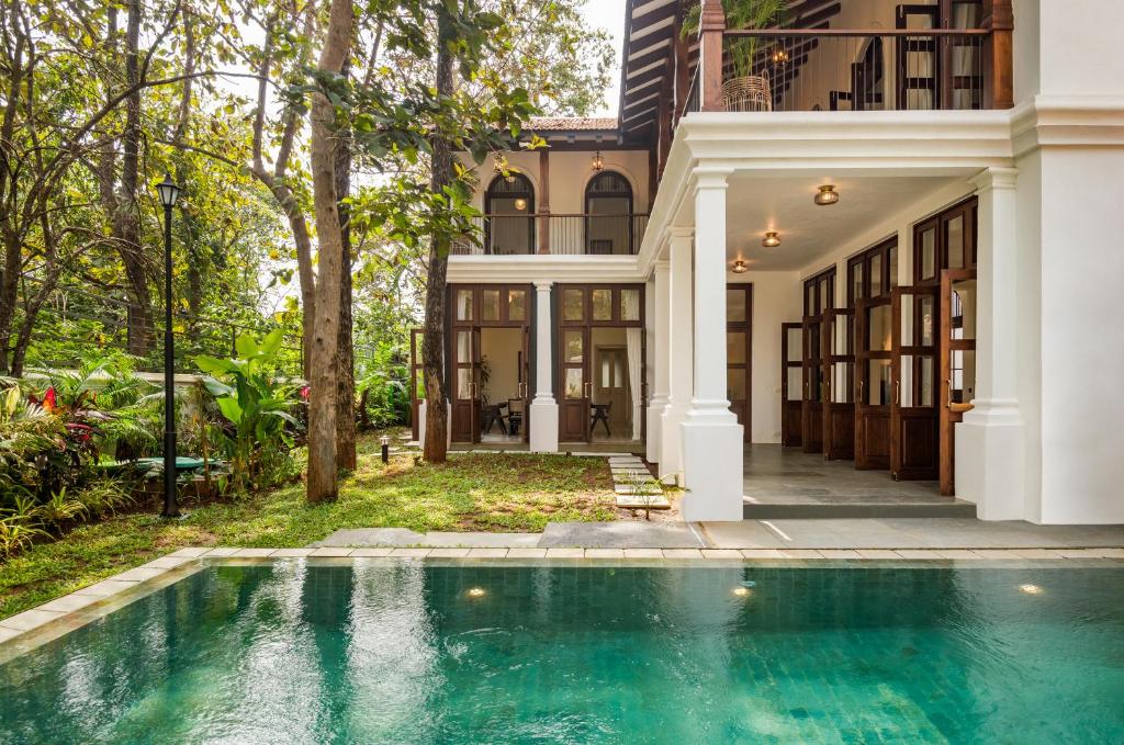 an exterior view of a house with a swimming pool at La Morella by The Blue Kite - Elegant 4BHK Villa in Assagao with Private Pool, Garden, Caretaker in Assagao