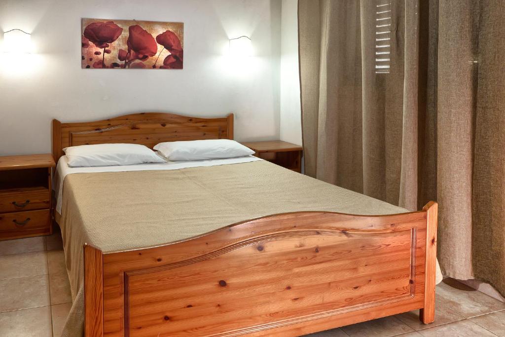 a bedroom with a wooden bed in a room at RESIDENCE CERRA in Otranto