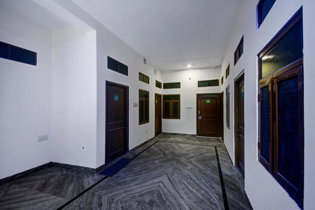 an empty hallway with white walls and wooden doors at Hotel O Vishal in Jaipur