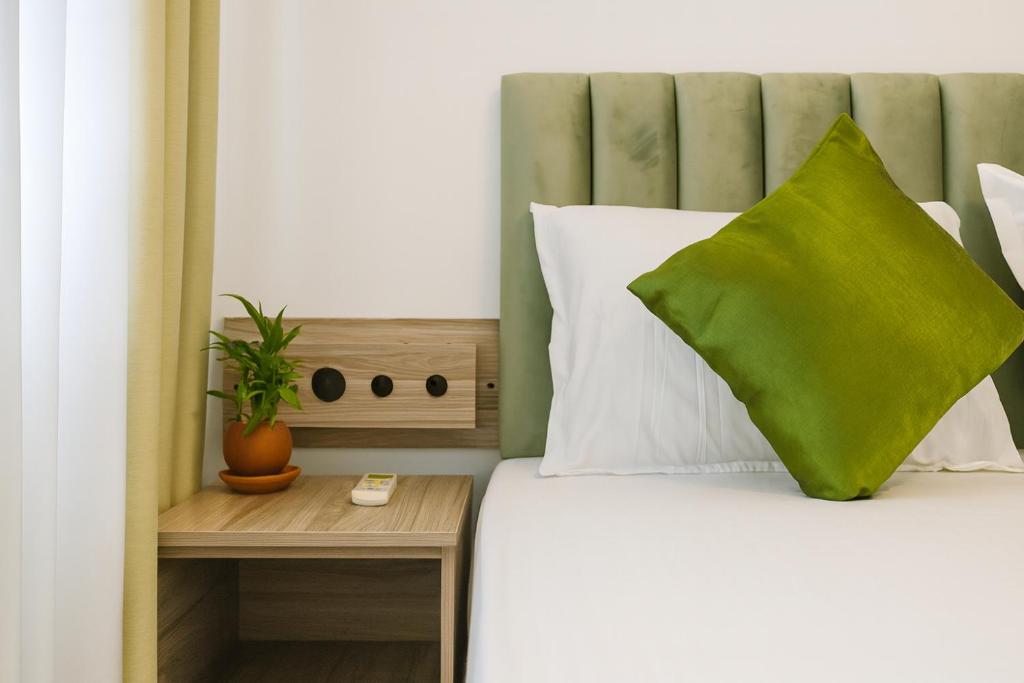 a bedroom with a bed with a green pillow at Skyport Villa Katunayaka in Katunayaka