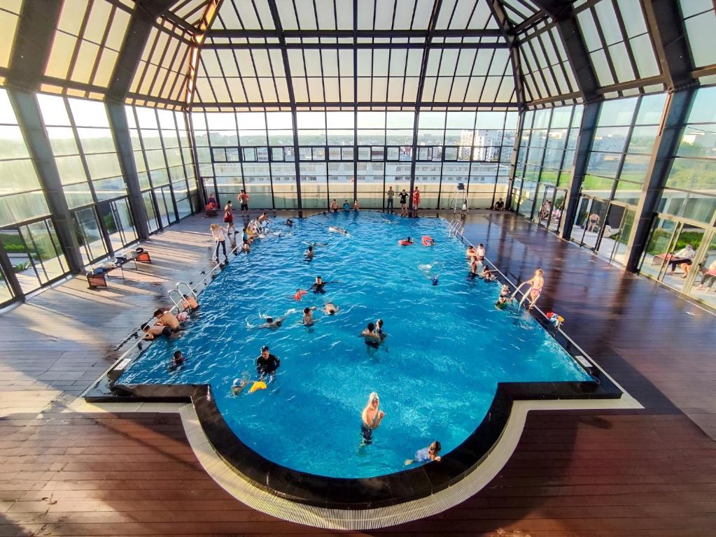 a group of people in a large swimming pool at Huế Nestory Homestay in Thôn Trường Giang