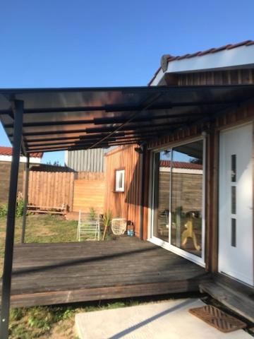 une terrasse couverte d'une maison avec une terrasse en bois dans l'établissement Petite Maison T2, à La Celle-sous-Gouzon