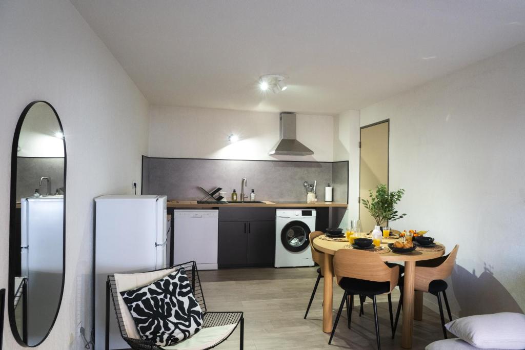 Una cocina y un comedor con mesa y sillas. en Appartement moderne, 2 chambre, Hyères centre, en Hyères