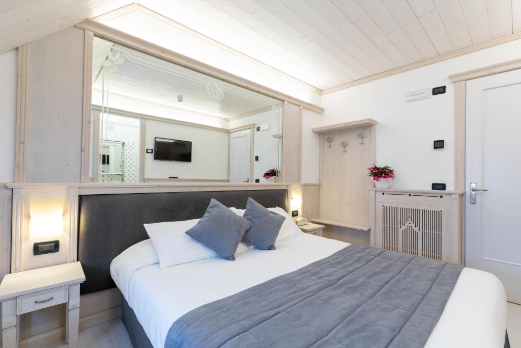 Un dormitorio con una cama grande con una ventana grande. en Hotel Croce Bianca, en Asiago