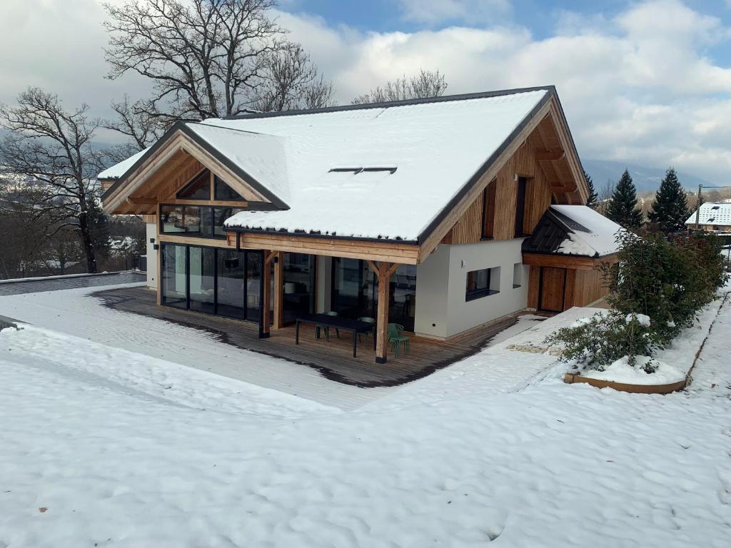 une maison avec un toit couvert de neige dans l'établissement Chalet Rossanaz, à La Motte-en-Beauges