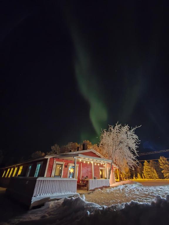 a cabin with the aurora in the sky at Kaamasen Kievari in Kaamanen