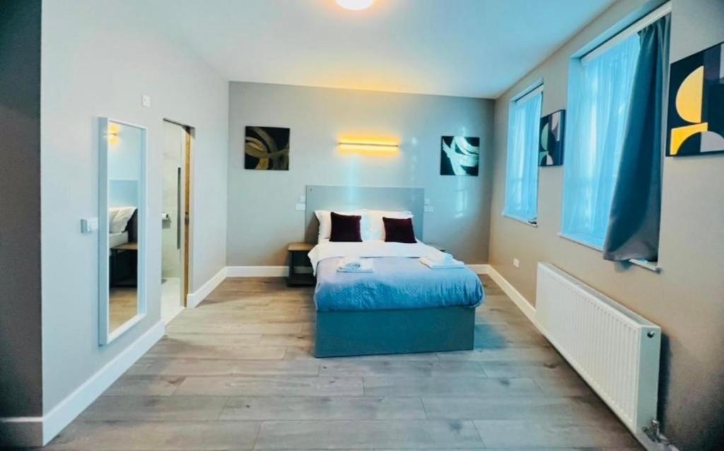 a bedroom with a bed and a large mirror at Paragraph Tottenham in Southgate