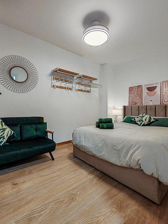 a bedroom with a bed and a couch and a mirror at Black Lion in Villena