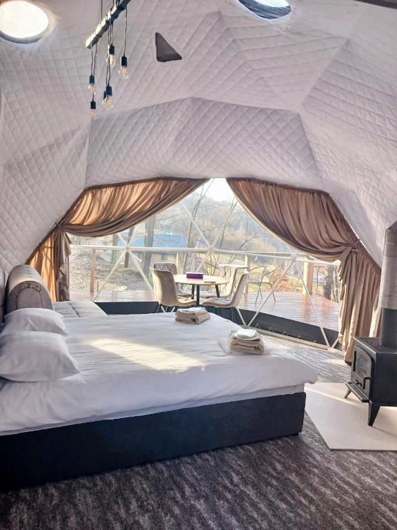 a bedroom with a large bed and a large window at SVOI Chalet in Vyshka