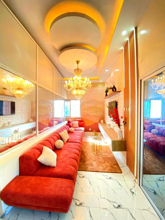 a living room with a red couch with pillows at Eden- Jacuzzi Privé et Terasse à 5mn de la plage in Dakar