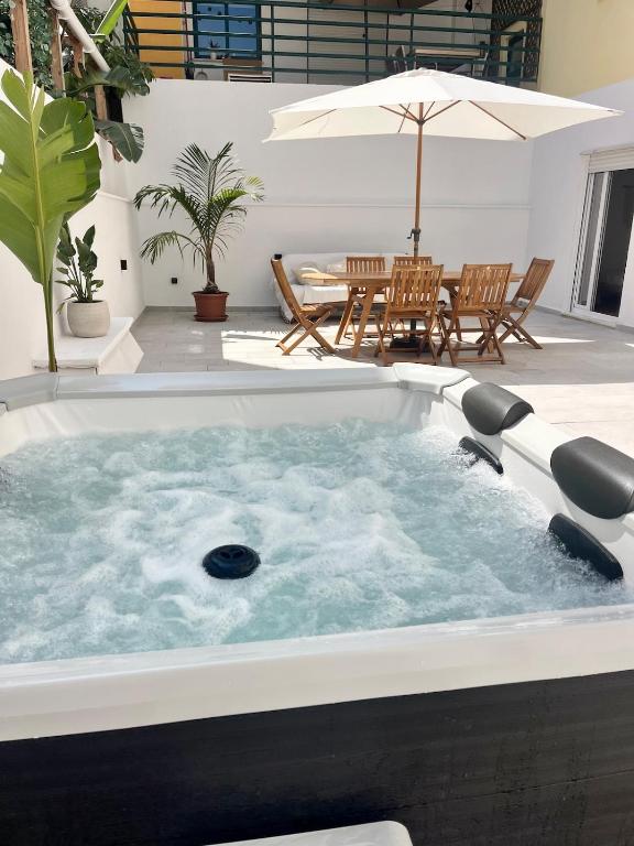 a jacuzzi tub in the middle of a patio at Miguel Surf House in Costa da Caparica
