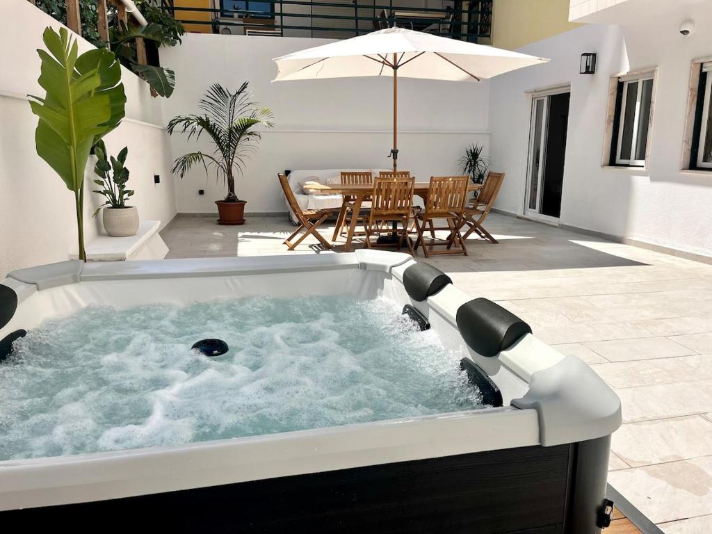 a jacuzzi tub in the middle of a patio at Miguel Surf House in Costa da Caparica