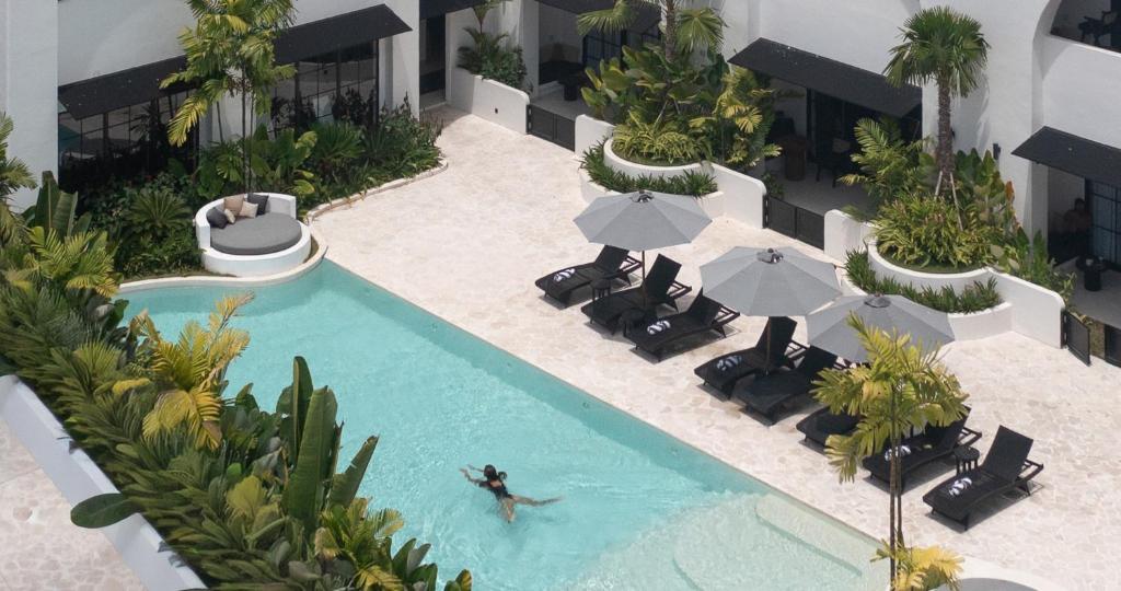 坎古Kiara Ocean Place的带椅子和遮阳伞的泳池俯视图
