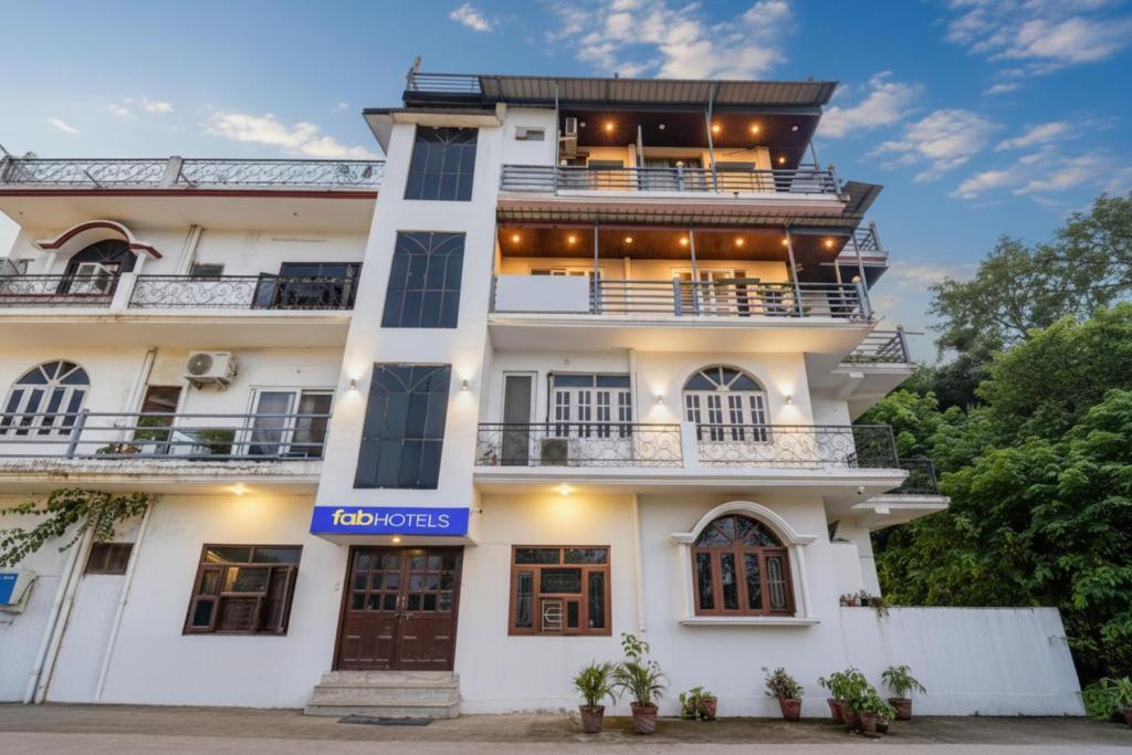 FabHotel Doon Classic Homestay في دهرادون: مبنى ابيض كبير عليه لافته