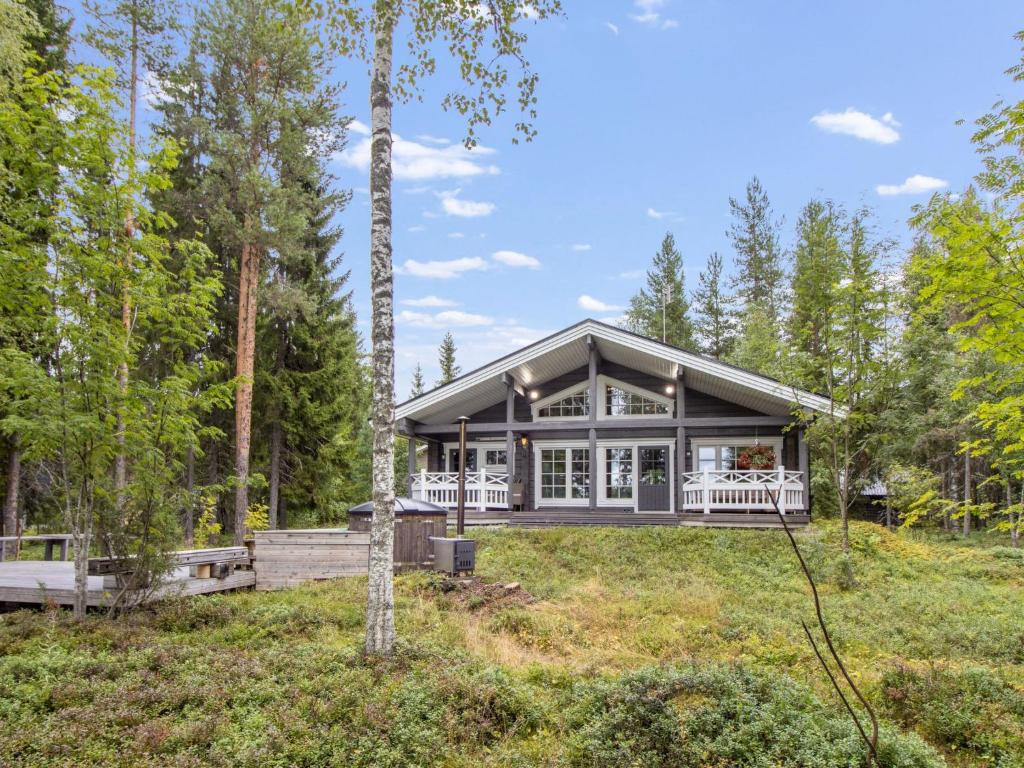 a home in the woods with a wrap around porch at Holiday Home Villa white water by Interhome in Kainuu