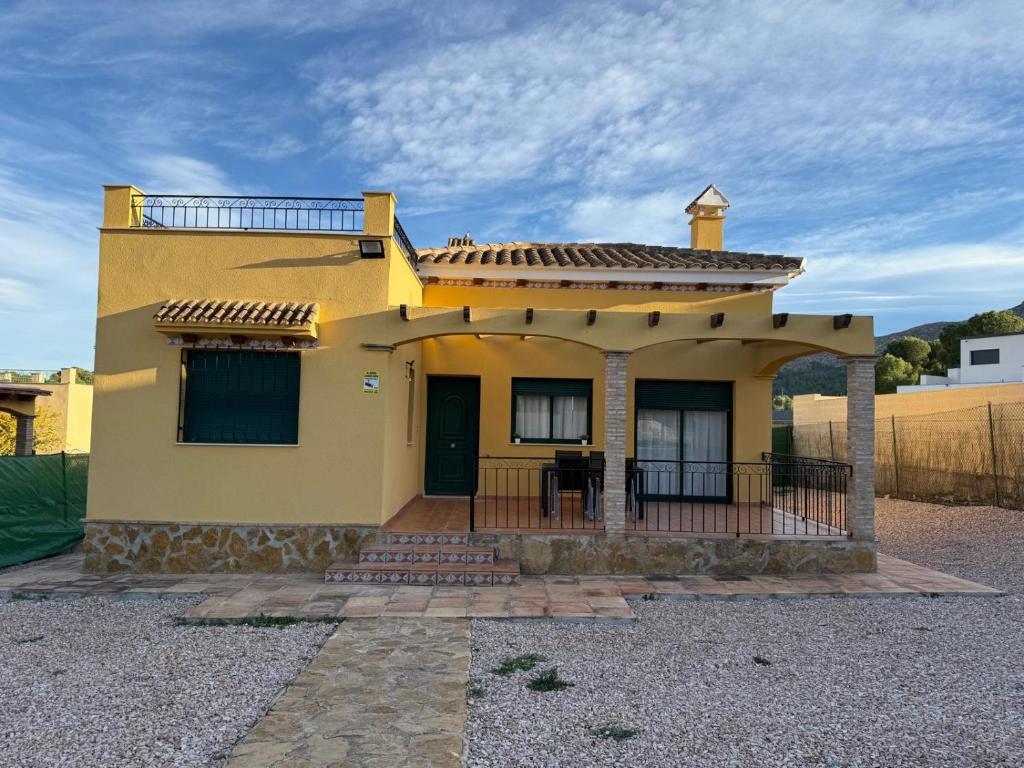 una casa gialla con portico e balcone di Casa tres soles a Calasparra