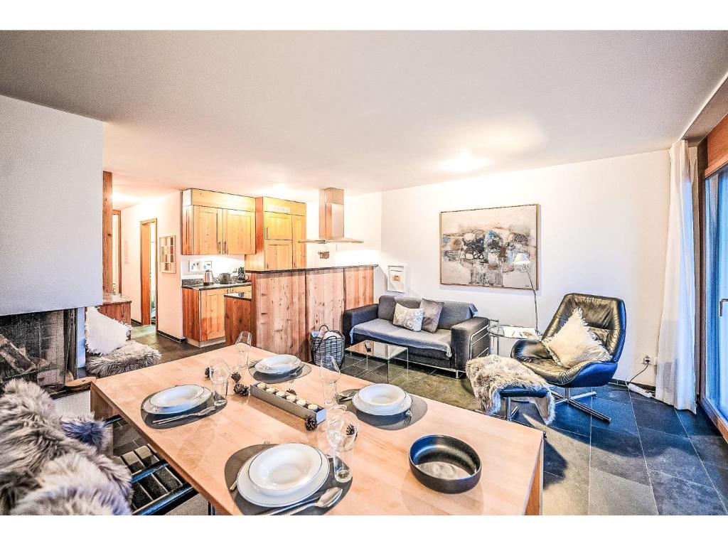 Una sala de estar con una mesa y una cocina. en Apartment Chesa Promulins by Interhome, en Samedan