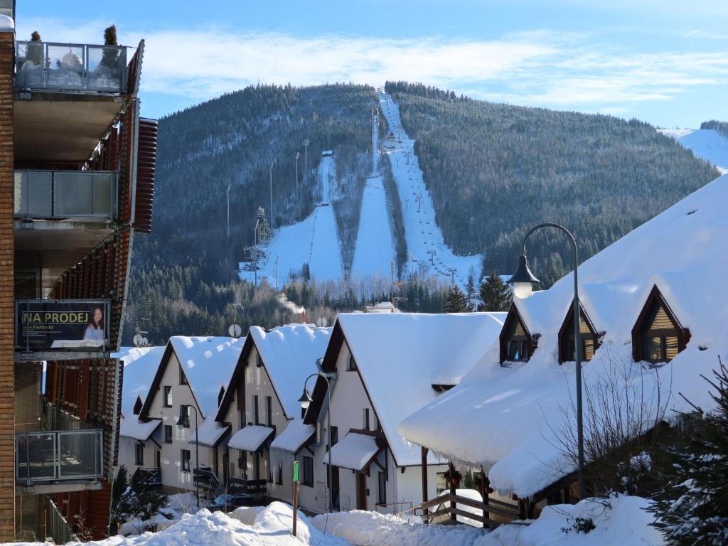 a snow covered town with a ski slope on a mountain at Studio Čertovka-3 by Interhome in Harrachov
