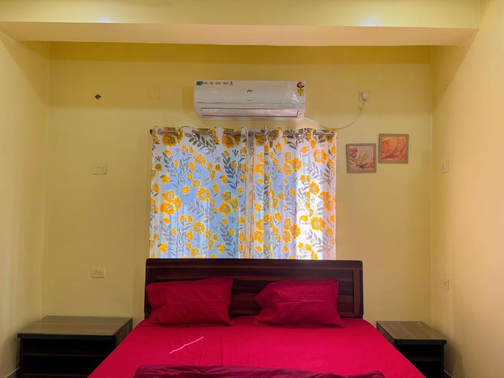ein Schlafzimmer mit einem Bett mit roten Laken und einem Fenster in der Unterkunft Studio 402 Continental stay in Deoghar