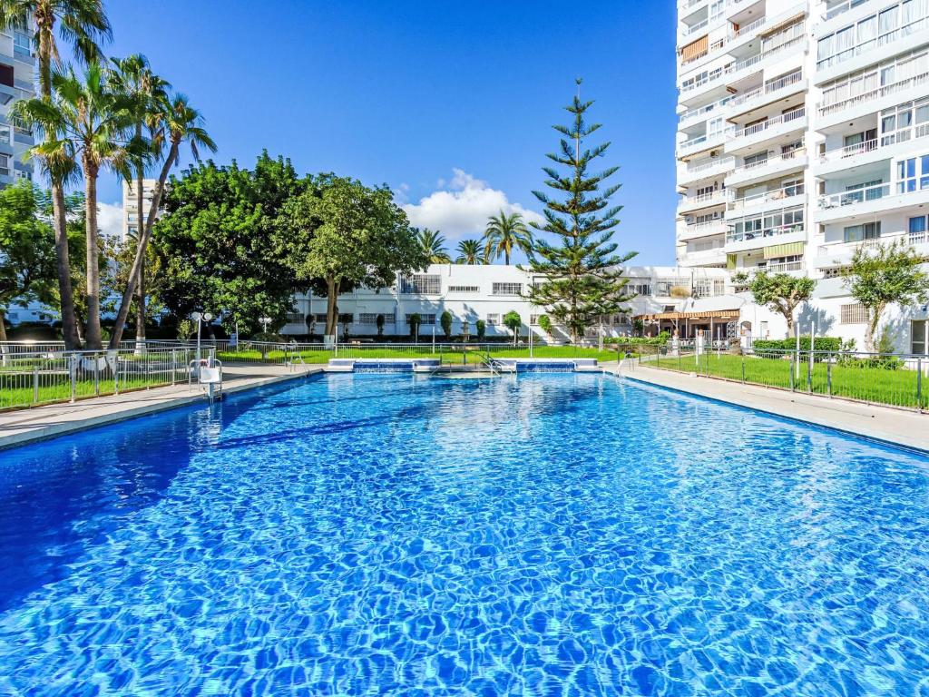 ein großer blauer Pool mit Gebäuden im Hintergrund in der Unterkunft Apartment Diana by Interhome in Benalmadena Costa