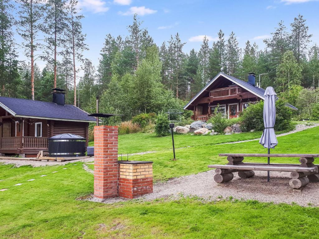a picnic table with an umbrella in front of a cabin at Holiday Home Nurmirinne by Interhome in Nurmes