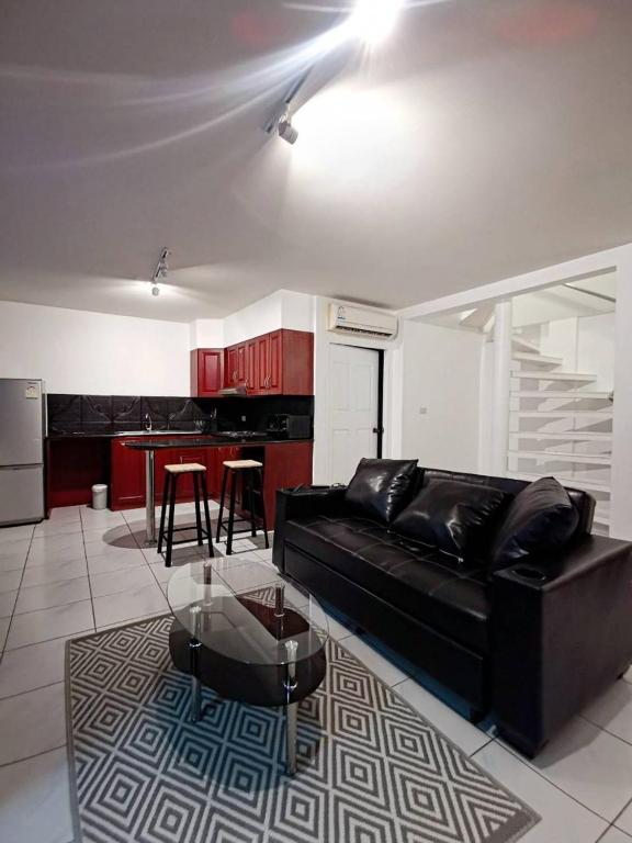 a living room with a black couch and a table at Townhome 45 in Ban Nong Pru