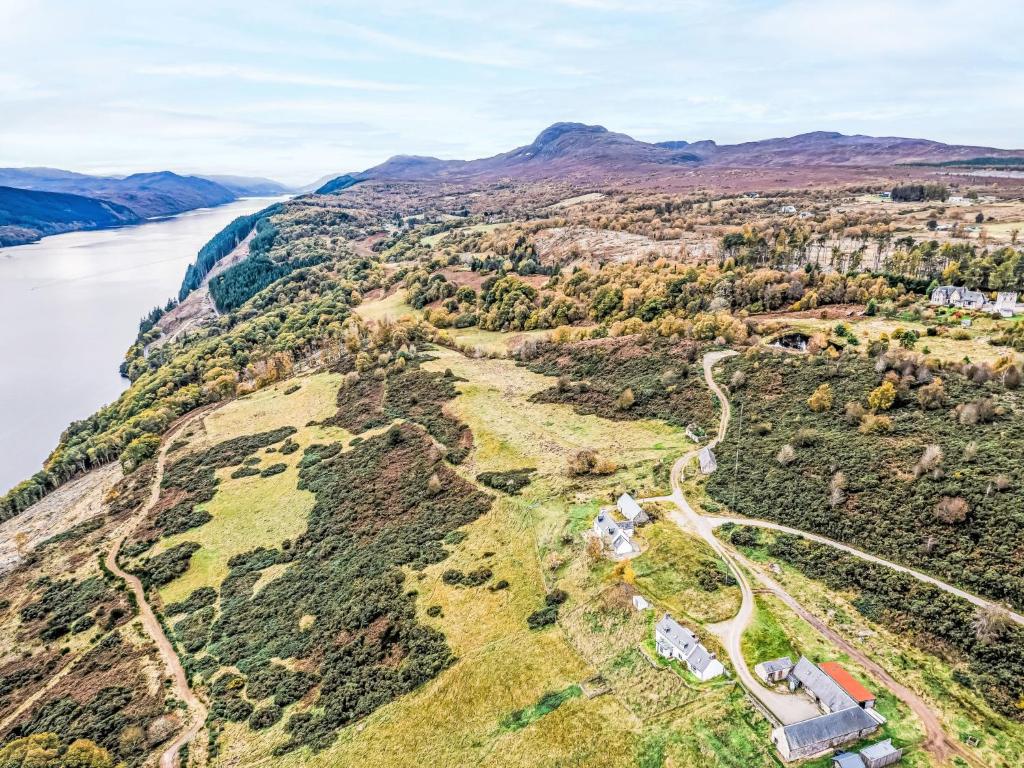 Holiday Home Bunloit Farmhouse by Interhome في Inverfarigaig: منظر جوي لتل مع نهر وجبال