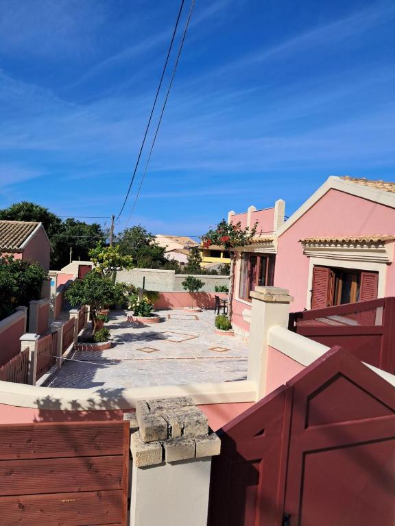 a view from the balcony of a pink house at Krista House in Agios Gordios