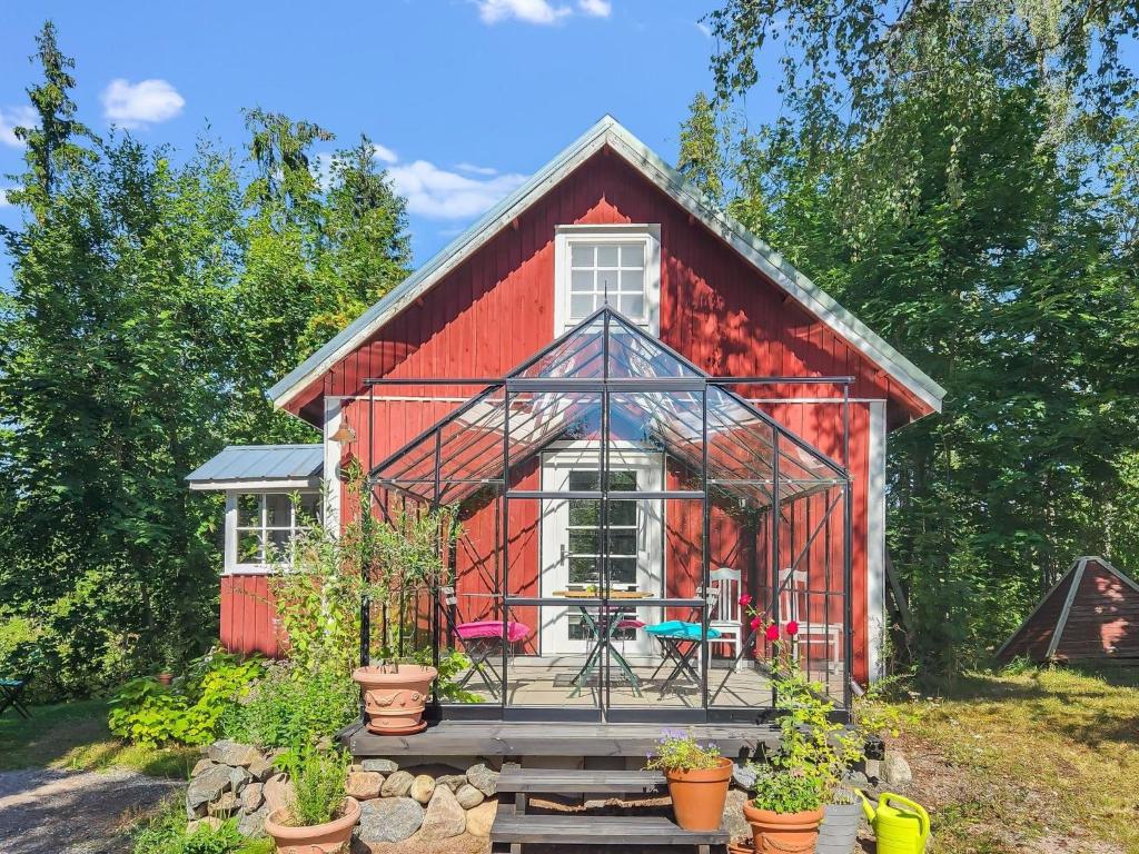 Holiday Home Den lilla röda stugan by Interhome في Kårkulla: حظيرة حمراء مع نباتات أمامها