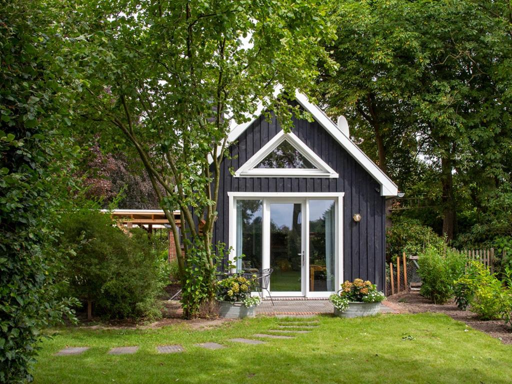 een zwart huis met een raam in een tuin bij Ferienhaus Clara in Klein Scharrel