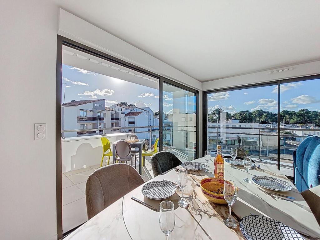 a dining room with a table and a large window at Apartment Veleda by Interhome in La Palmyre