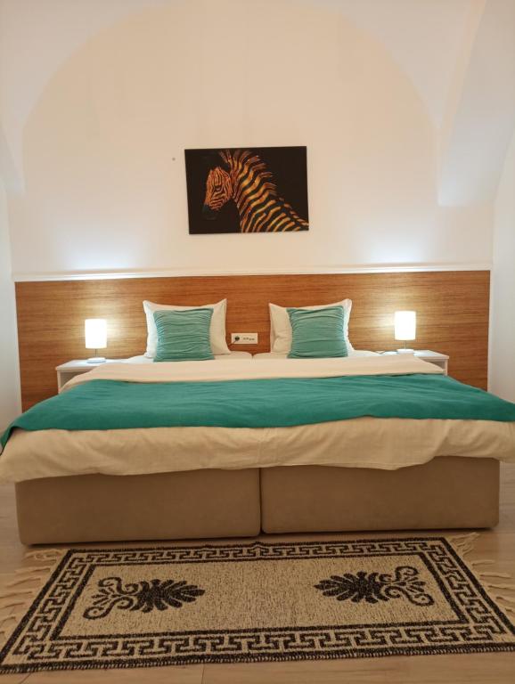 um quarto com uma cama grande e uma imagem de zebra na parede em Apartment GARDEN 1 CENTER em Novi Sad