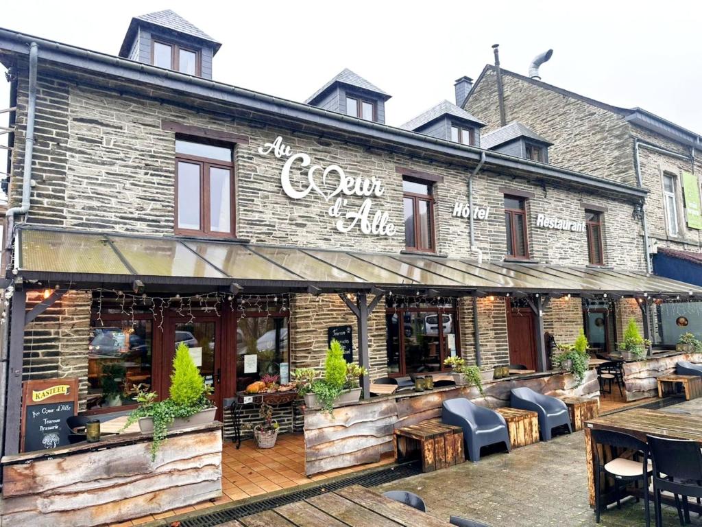 a store front of a brick building with tables and chairs at Au Coeur d'Alle by Belvilla in Alle