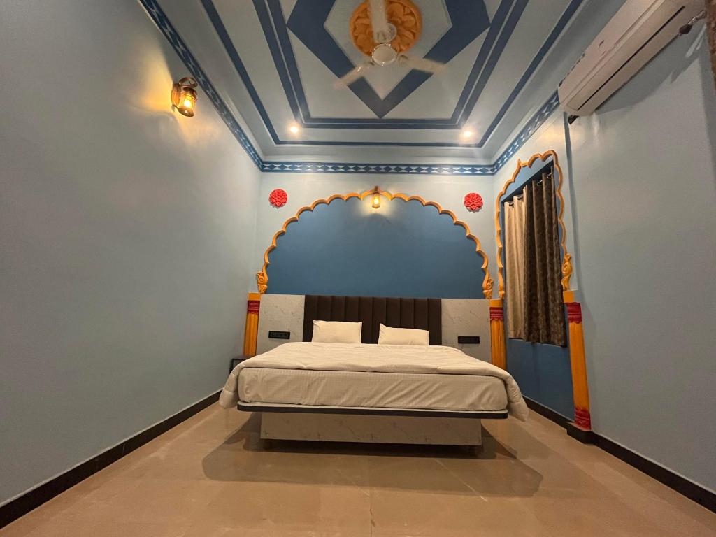 een slaapkamer met een bed met een blauw plafond bij Hotel Simran Desert View Haveli in Pushkar