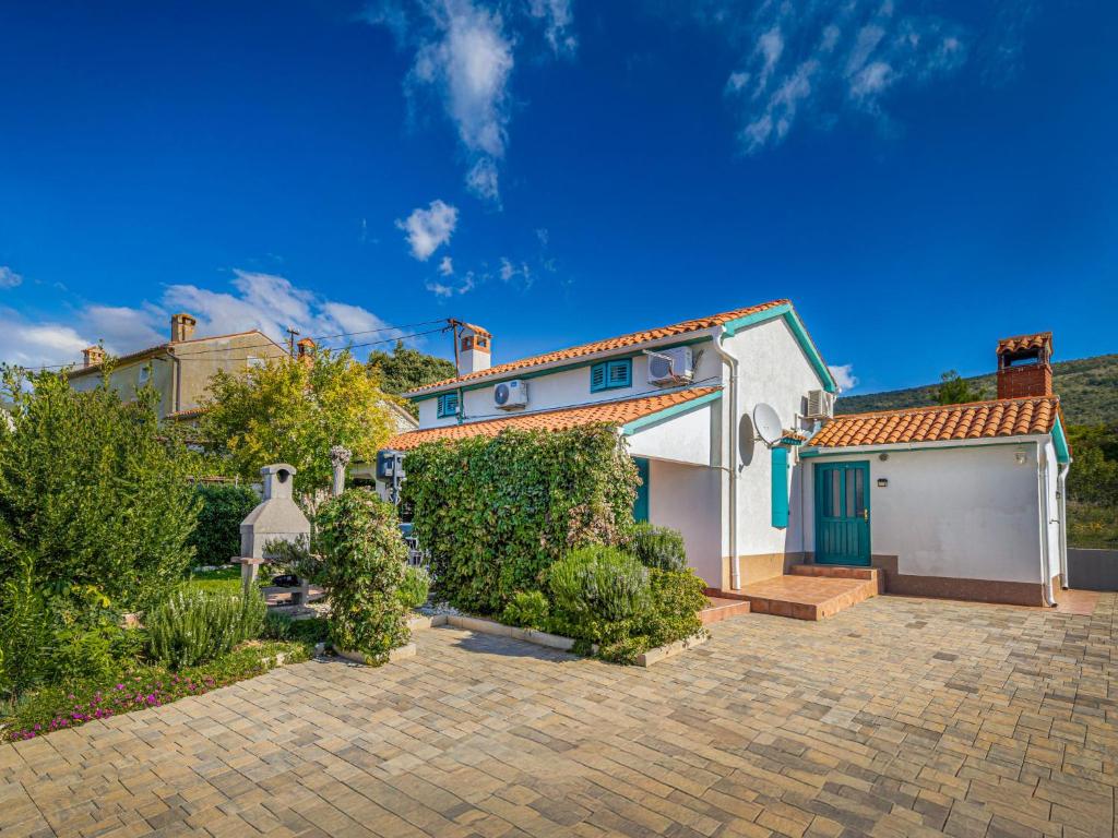 a white house with a garage in a yard at Holiday Home Adele by Interhome in Labin