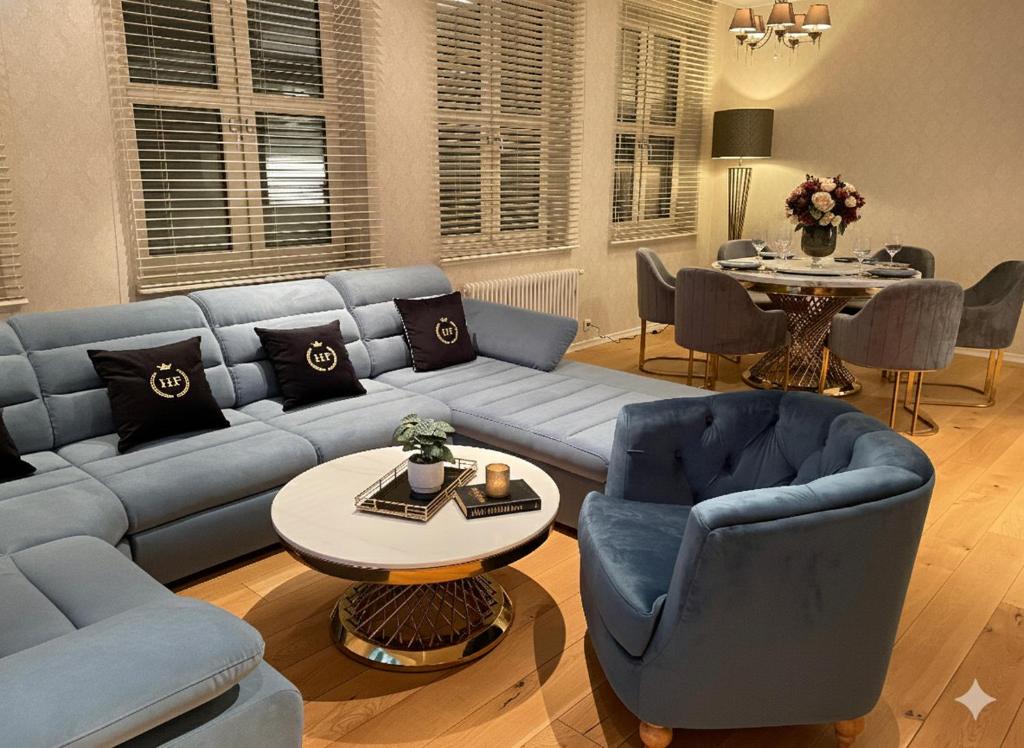 a living room with a blue couch and chairs and a table at Apartament Faltom 7 Gdynia Centrum Abrahama in Gdynia