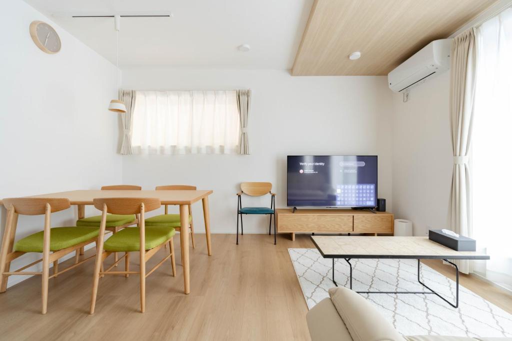 a living room with a table and chairs and a tv at AMBLE Asakusa in Tokyo