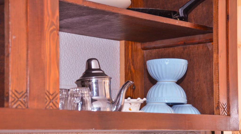 ein Holzregal mit Geschirr und Vasen darauf in der Unterkunft blue wave residense tamraght in Tamraght Ou Fella