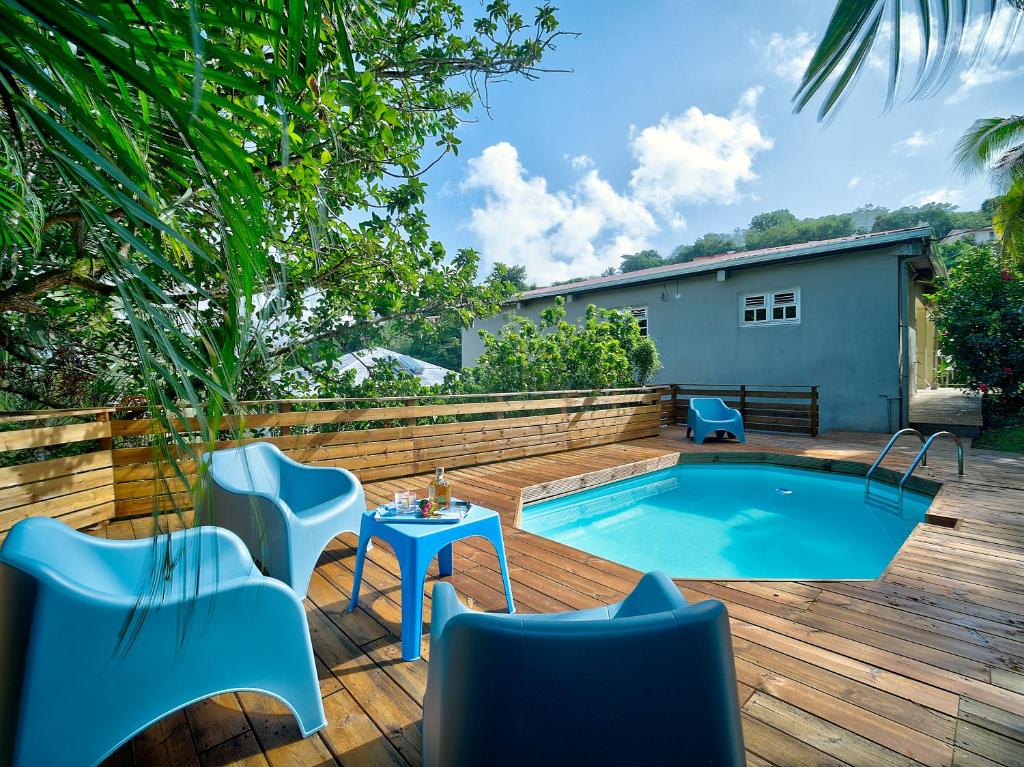a backyard with a pool and a table and chairs at Villa Zenitude Caraïbes in Les Trois-Îlets