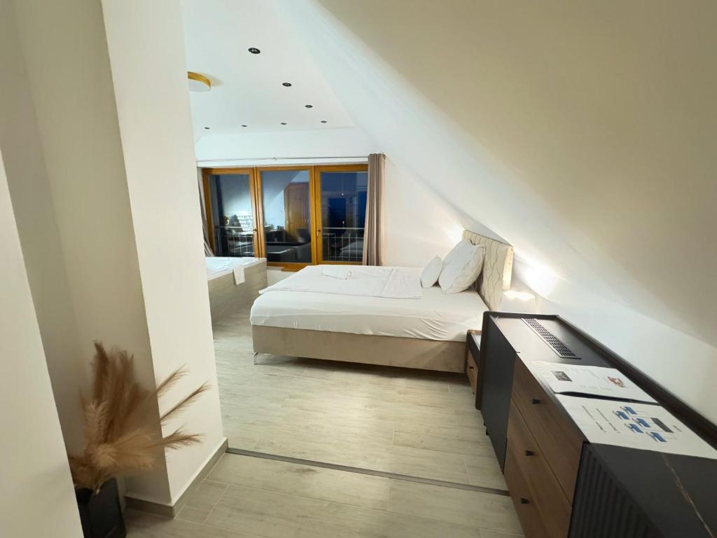 a small bedroom with a bed and a bathroom at Szent László Residence in Mátraszentimre