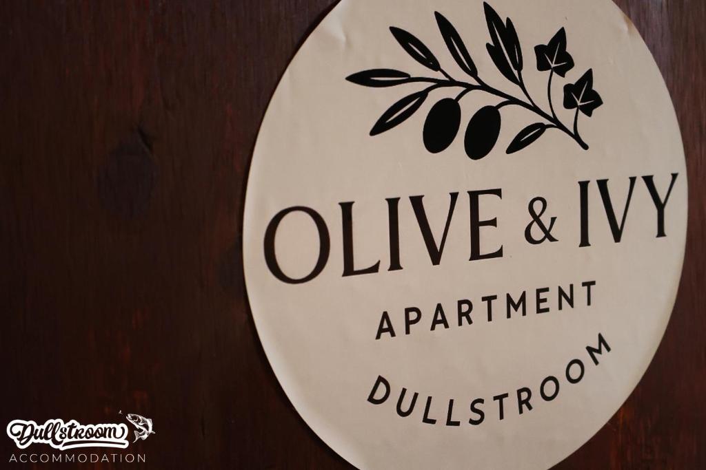 Et logo, certifikat, skilt eller en pris der bliver vist frem på Olive & Ivy Cherry Grove 7