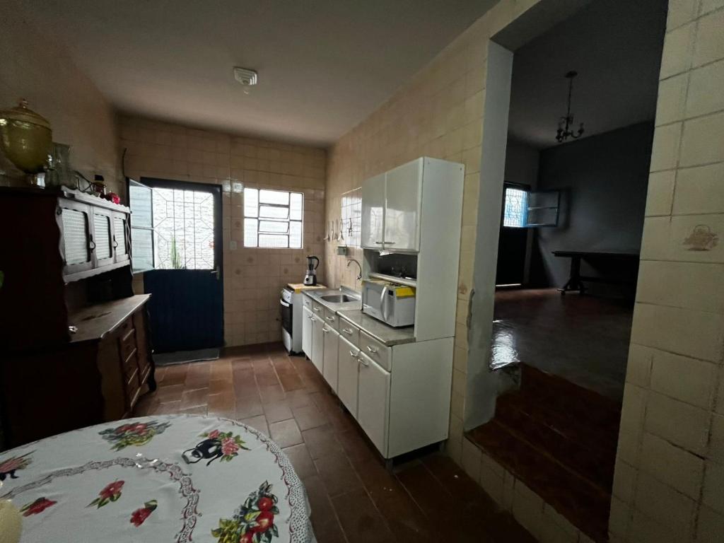 a kitchen with a white refrigerator and a stove top oven at Pousada Papirella in São Gabriel