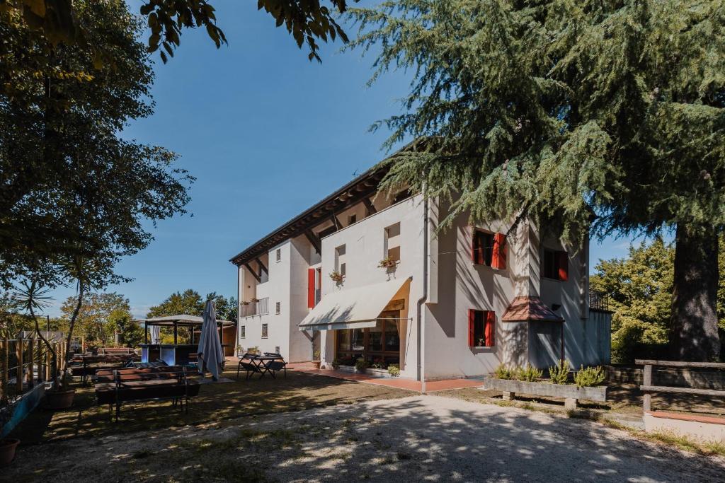 a large white building with a tree in front of it at Agriturismo P rato Fiorito in Santi Angeli