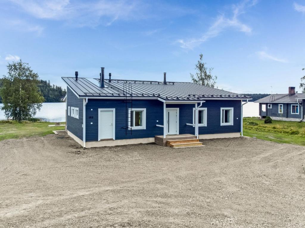 una casa blu situata in cima a un terreno sterrato di Holiday Home Tervaleppä by Interhome a Sipsiö