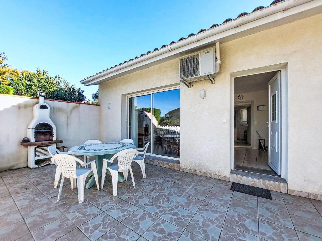 Holiday Home Laplace by Interhome في سوستون: فناء مع طاولة وكراسي وشرفة