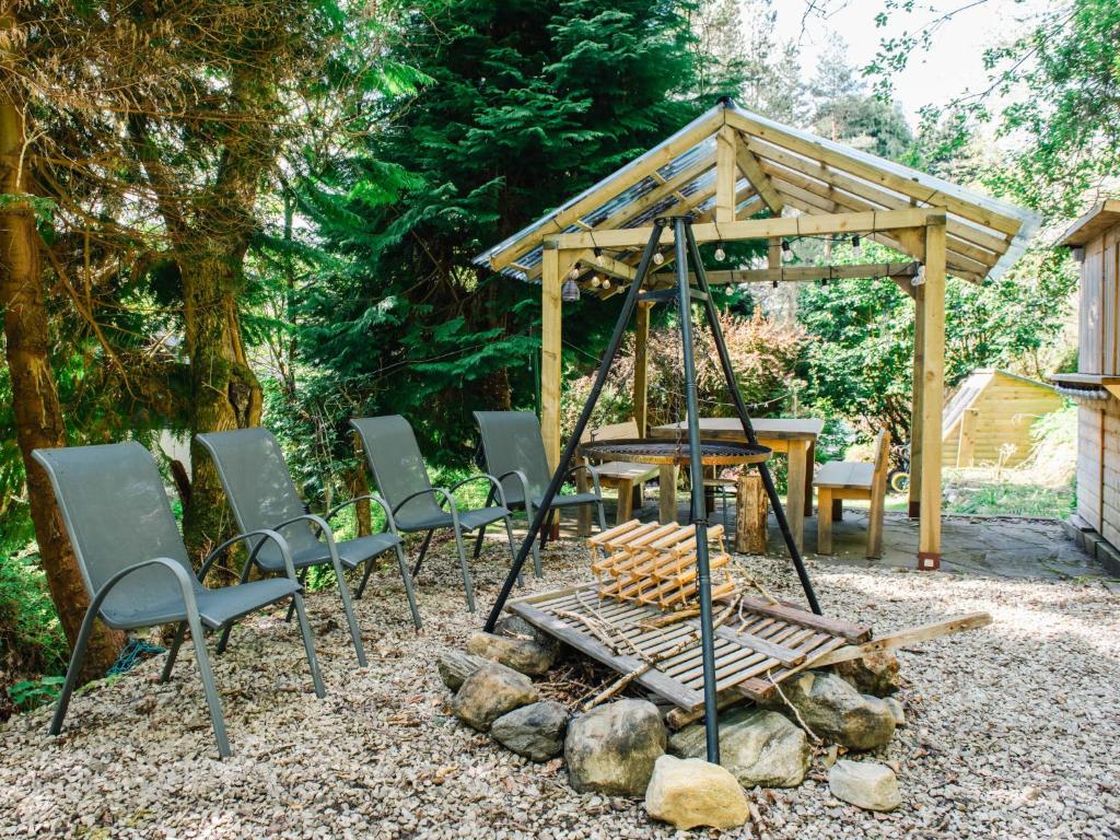 un grupo de sillas y un columpio en un patio en Holiday Home Wayside Bothy by Interhome, en Drumnadrochit