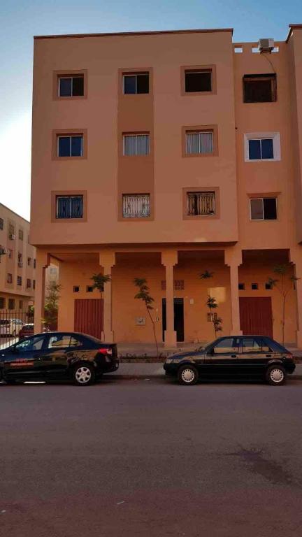 two cars parked in front of a building at Licht & ruim 2-slaapkamer appartement met airco & Wifi - rustig wijk Marrakesh in Marrakesh