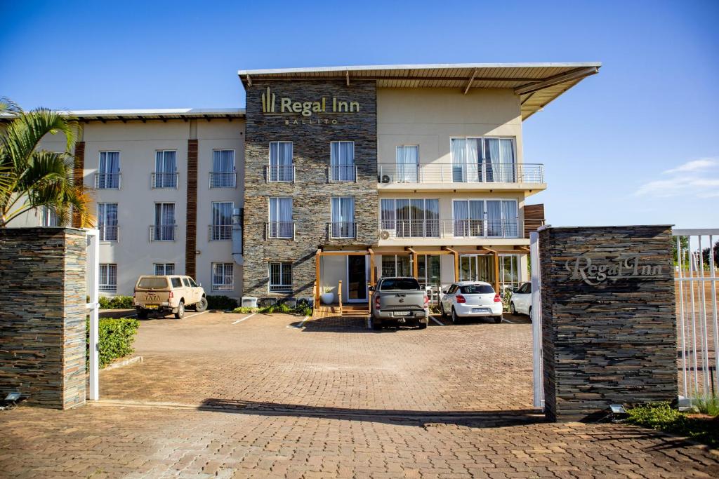an entrance to a hotel with cars parked in a parking lot at Regal Inn Ballito in Ballito