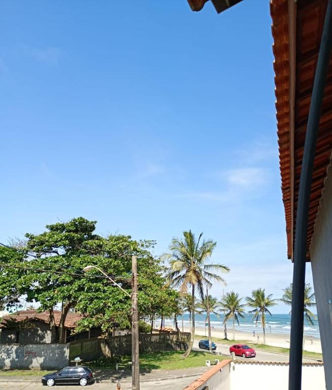 een uitzicht op een strand met palmbomen en de oceaan bij Casa Pé na Areia in Mongaguá