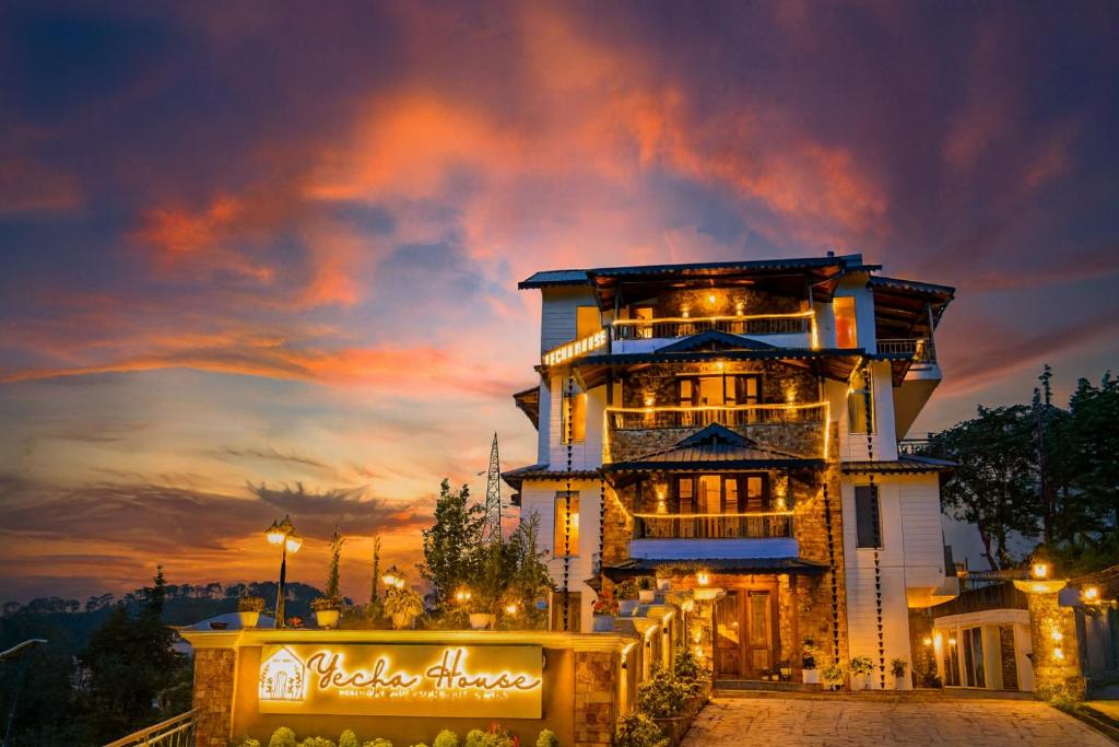 un edificio alto con un tramonto sullo sfondo di Yecha House - Mountain & Lake View Retreat, Bhimtal a Bhimtal